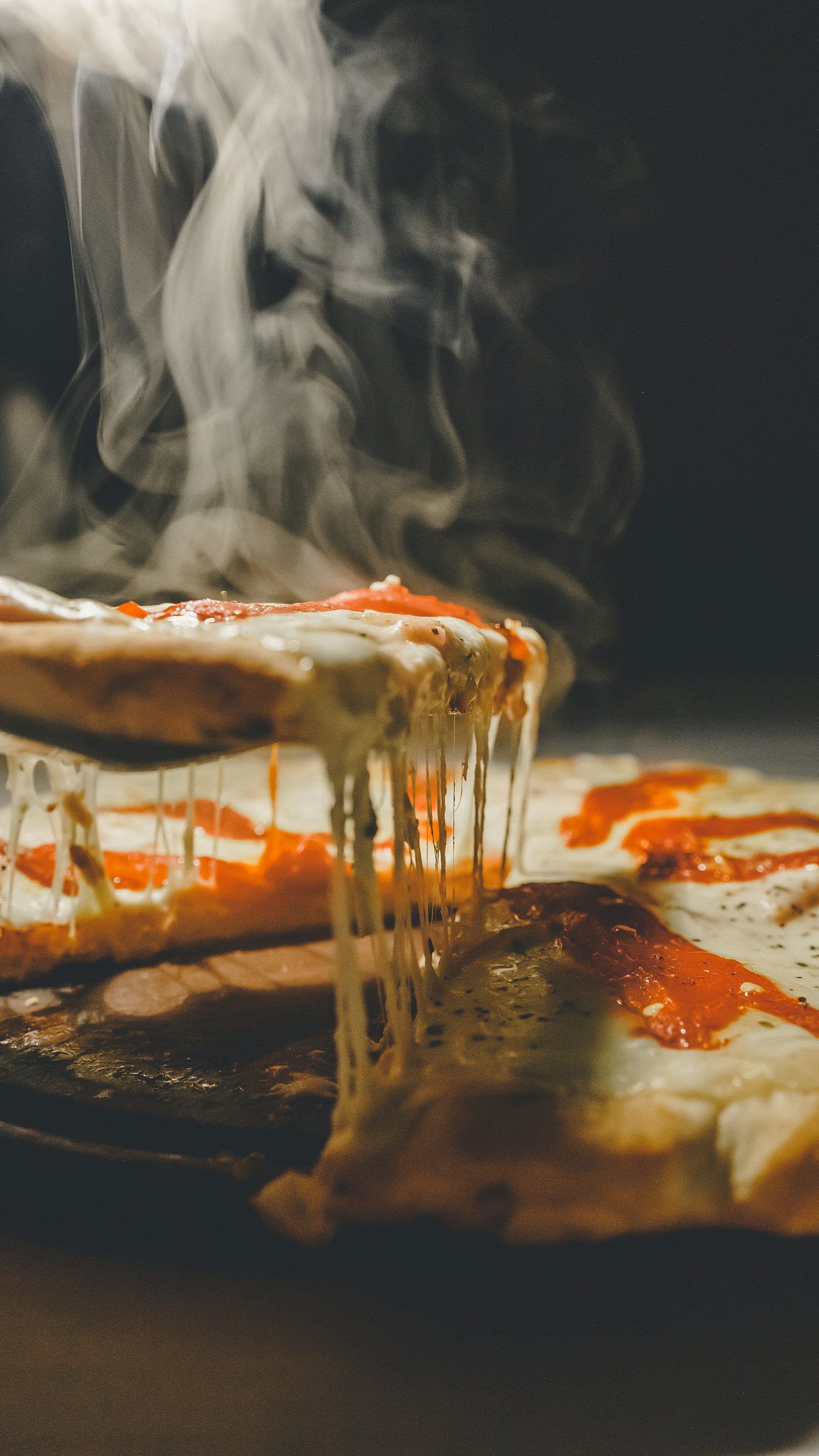 A slice being lifted from a pizza